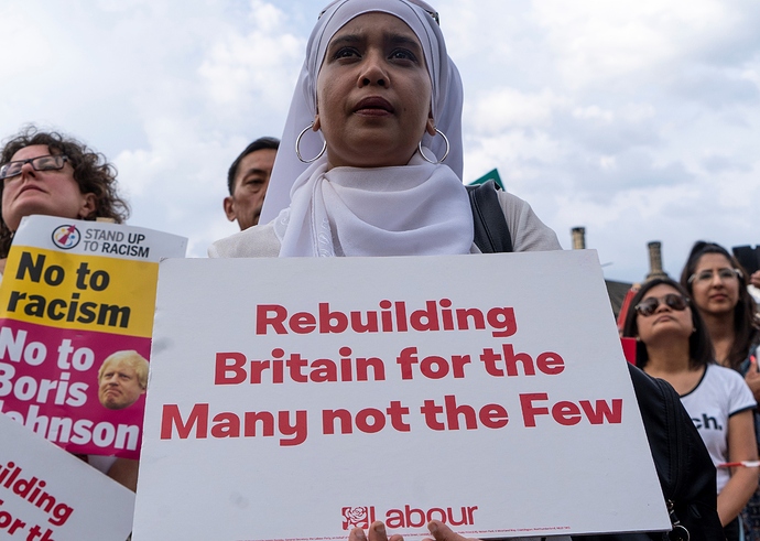 Supporters hold placards as Britain's opposition Labour party leader Jeremy Corbyn addresses a rally calling for a General Election now, in Parliament Square, central London on July 25, 2019.