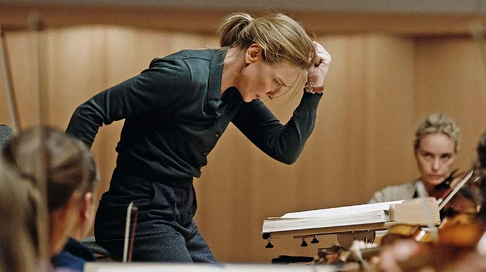 Cate Blanchett as Lydia Tár conducting an orchestra in the film Tár.
