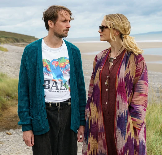 Tom Basden as Herb McGwyer and Carey Mulligan as Nell Mortimer looking at each other on a beach.
