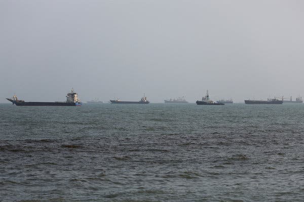 A group of shipping vessels and other boats on the horizon in the Strait of Hormuz.