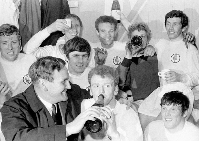 Leeds United players celebrate with champagne and cigars in the dressing room after winning the Division One Championship title.