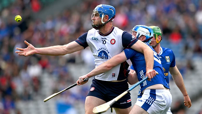 Johnny Glynn of New York with an outstretched arm attempts to catch a yellow ball while Enda Shalvey of Cavan tackles him during the Lory Meagher Cup Final.